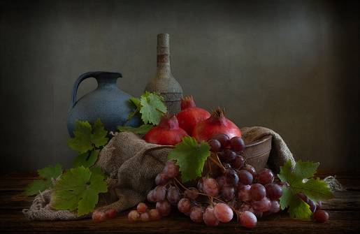 Still life with pomegranate and grape in vintage style.