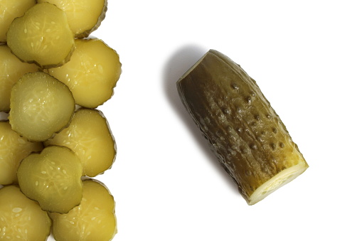 Three pickled cucumbers lie on a white background.