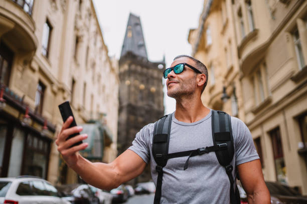 istock Young man with backpack holding smartphone during sightseeing tour. 1662431917