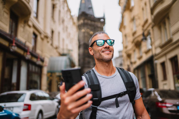 istock Young man with backpack, taking a selfie on the street on smartphone . 1662432926