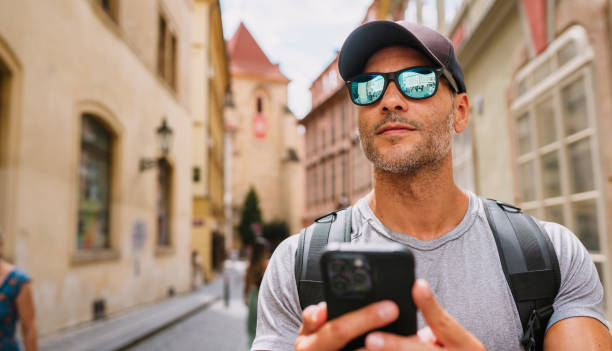istock Man walking down the street with cell phone in hand. 1662438232