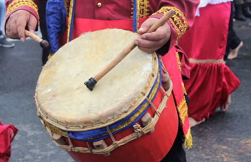 Someone is beating a traditional Minahasa drum at a cultural carnival event in Indonesia.
