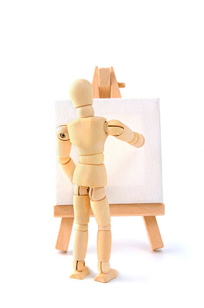 istock Wooden mannequin painting on a canvas with copyspace 166246245