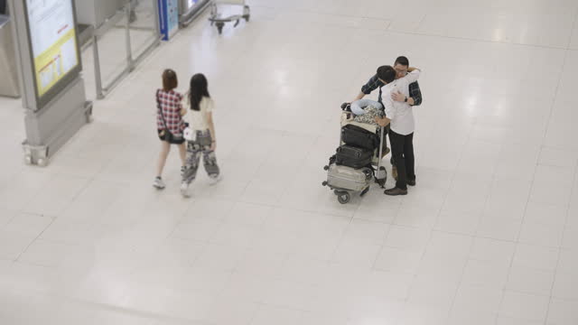 Long time no see. Two Man hugging each other when they come back from somewhere in airport