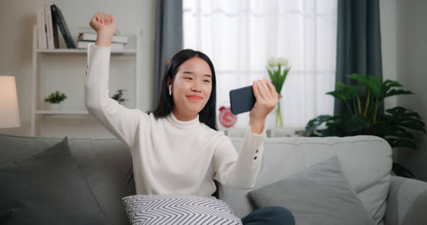 istock Asian woman playing a game on smartphone 1662506040
