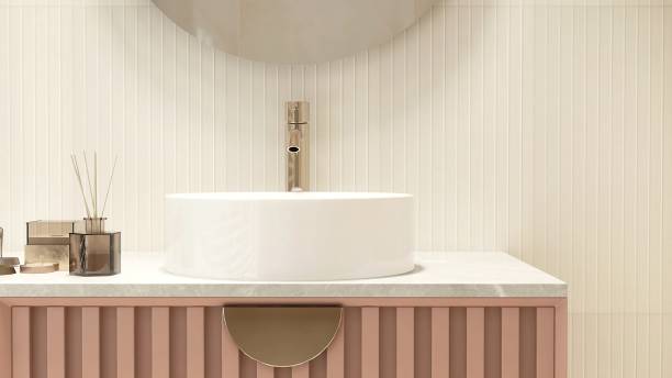istock Reed stick diffuser, white round washbasin on marble vanity countertop, pink corrugated counter, round mirror in cream wainscot wall bathroom 1662509199