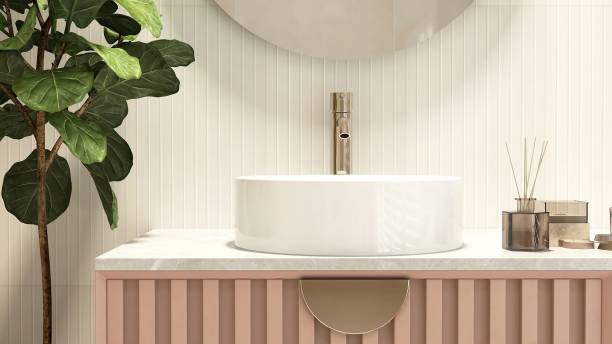 istock Reed stick diffuser, white round washbasin on marble vanity countertop, pink corrugated counter, green fiddle leaf fig tree in cream wainscot wall bathroom 1662509200