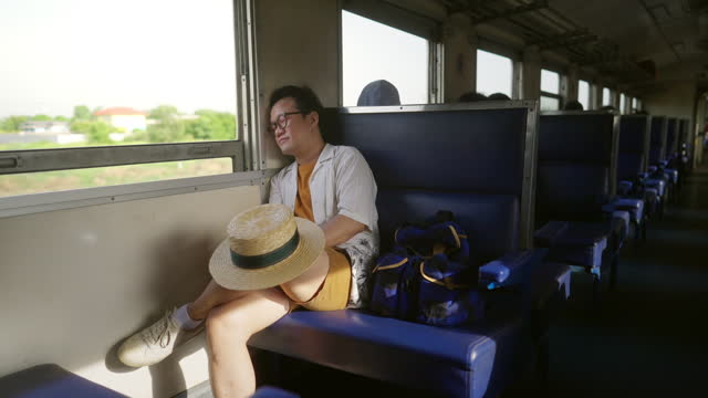 4K Asian man tourist travel in Thailand on local train.