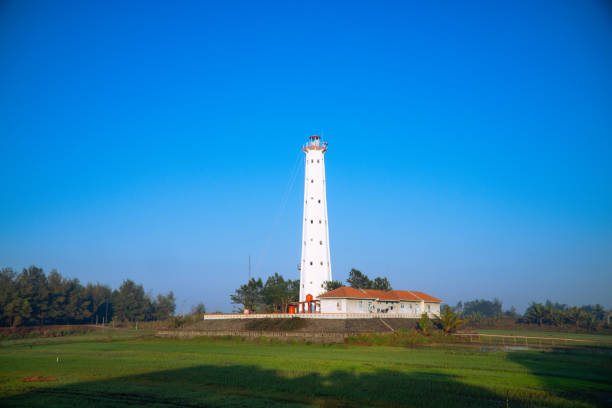 istock White lighthouse with green meadow on foreground and clear blue sky 1662563088