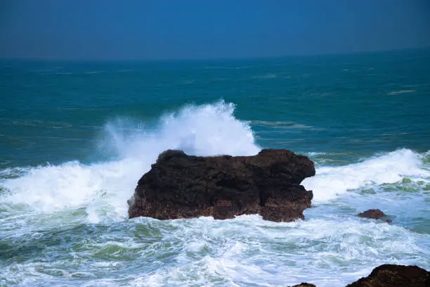 Photo of A panoramic view of rocky coastline hits by the wave.