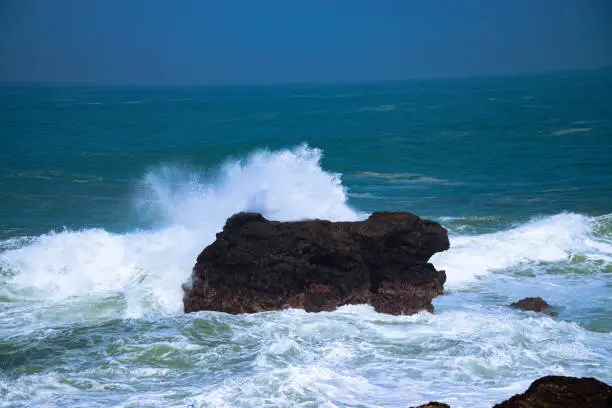 Photo of A panoramic view of rocky coastline hits by the wave.