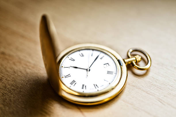 gold vintage pocket watch on wood table
