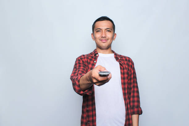 istock Asian man holding remote tv 1662594744