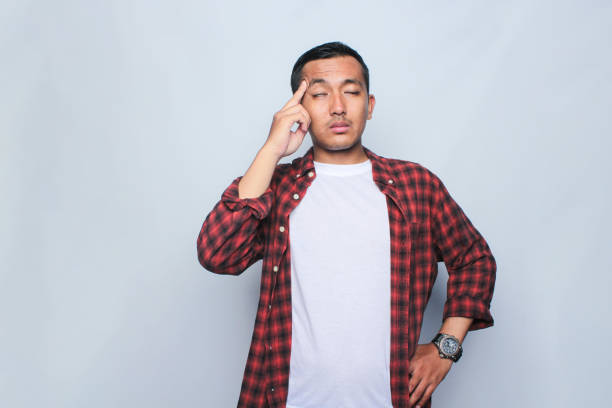 Portrait of Asian young man got headache on white background.