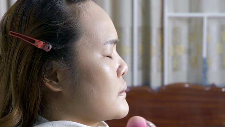 Makeup artist putting foundation on her client's face.