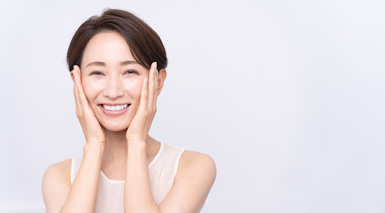 Skin care. An asian woman with beauty face is  touching healthy facial skin.