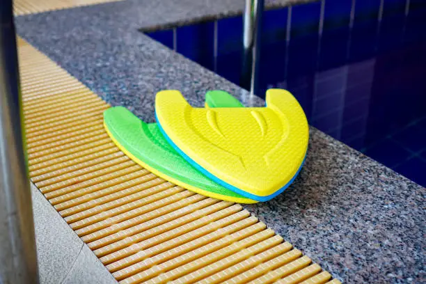 Pictures of swimming training foam placed at the edge of the pool, Kickboard.