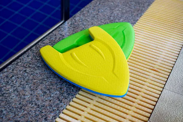 Picture of a close-up of the swimming training foam placed at the edge of the pool, Kickboard.