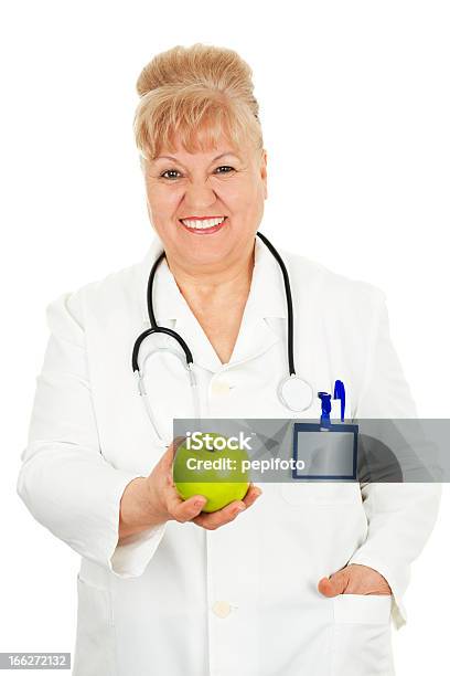 Medico Tenendo Una Mela - Fotografie stock e altre immagini di 55-59 anni - 55-59 anni, 60-69 anni, Adulto