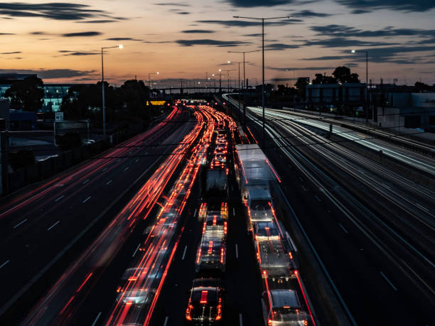 Multi lane free way with light trails and urban skyline