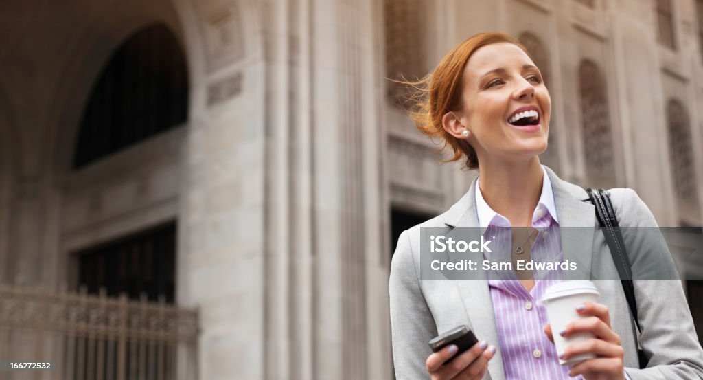Businesswoman using cell phone on city street  Headshot Stock Photo