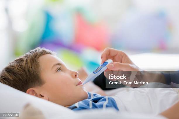 Mother Taking Sons Temperature Stock Photo - Download Image Now - 25-29 Years, 6-7 Years, Adult
