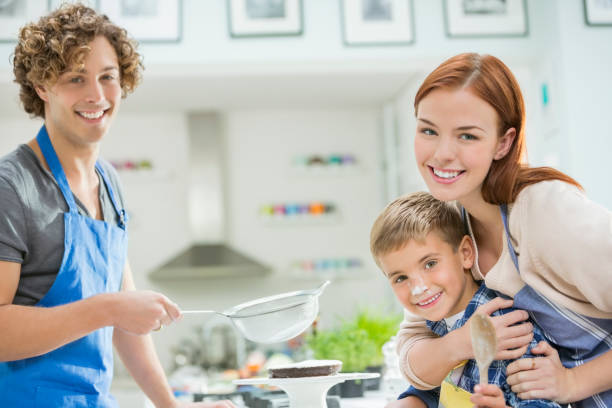 Family cooking together in kitchen  sprinkling powdered sugar stock pictures, royalty-free photos & images