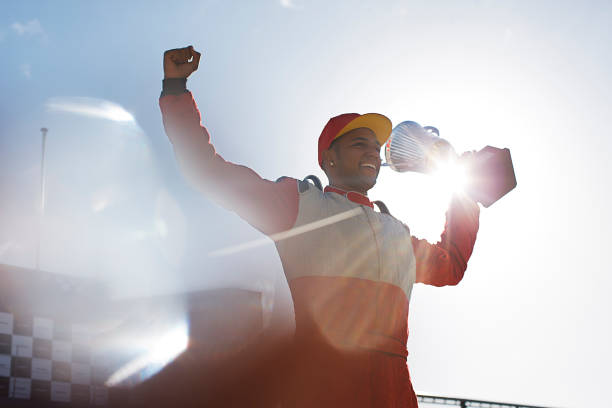 Cheering racer holding trophy on track  race car driver stock pictures, royalty-free photos & images