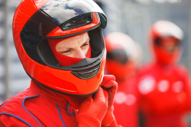 racer tying on helmet on track - helmet crash helmet motorized sport auto racing 뉴스 사진 이미지