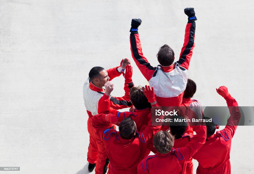 Racer and team cheering on track  Winning Stock Photo