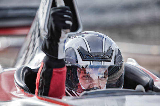 racer dando polegares para cima do carro de corrida - racing helmet imagens e fotografias de stock