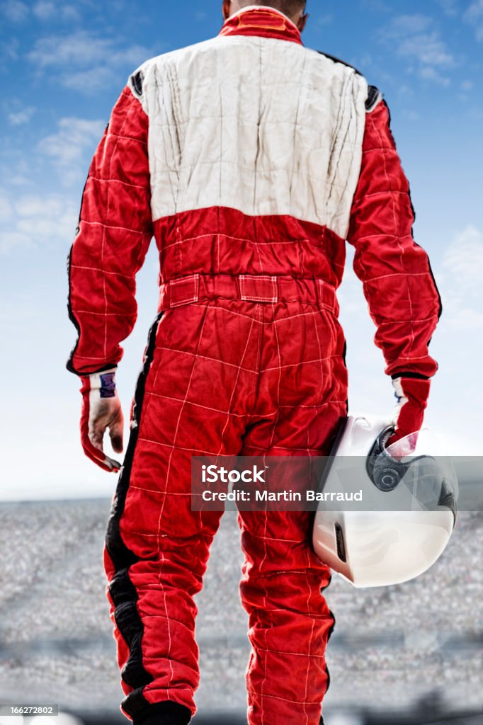 Racer carrying helmet on track  Auto Racing Stock Photo