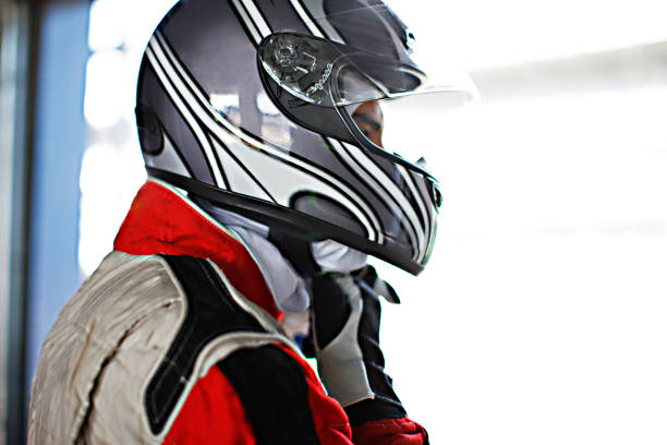 istock Racer tying on helmet in garage 166272808
