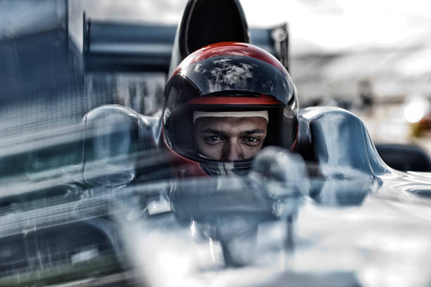 sitting in car racer - sports helmet stock-fotos und bilder