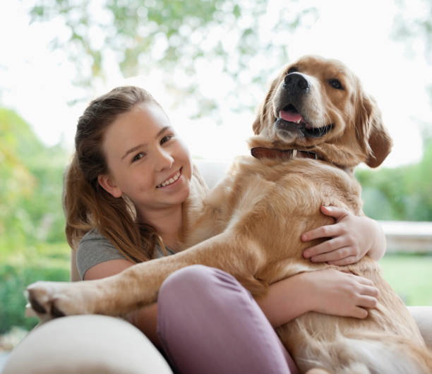 istock Smiling girl hugging dog on sofa 166272878