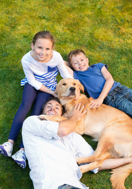 istock Family relaxing with dog on lawn 166272988