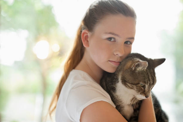 istock Girl holding cat indoors 166273037