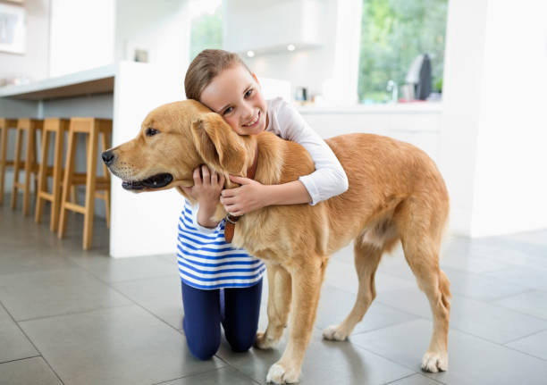 istock Smiling girl hugging dog in kitchen 166273103
