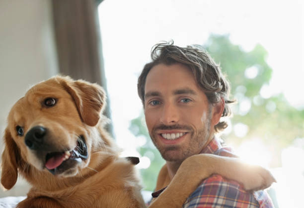 istock Smiling man petting dog indoors 166273110