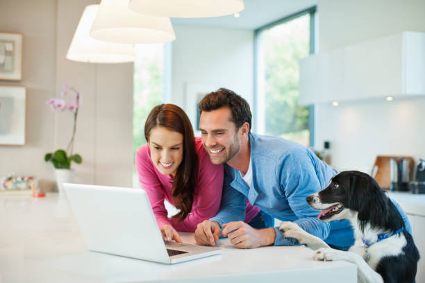 istock Couple using laptop with dog at table 166273158