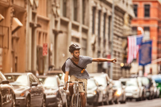 uomo andare in bicicletta in città street - hand sign foto e immagini stock