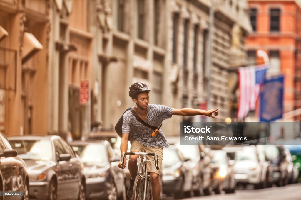 Man riding bicycle on city street  Hand Sign Stock Photo
