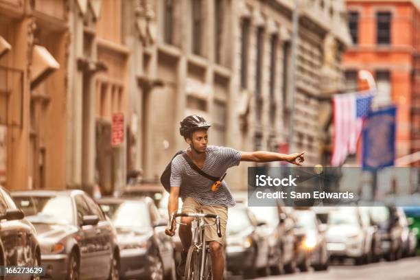 Man Riding Bicycle On City Street Stock Photo - Download Image Now - Hand Sign, Turn Signal, Cycling