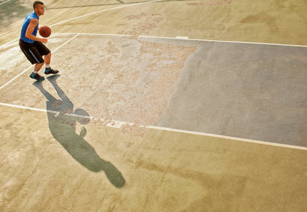 istock Man playing basketball on court 166273719
