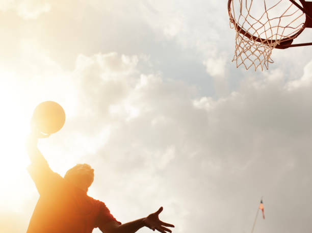 istock Man dunking basketball on court 166273760