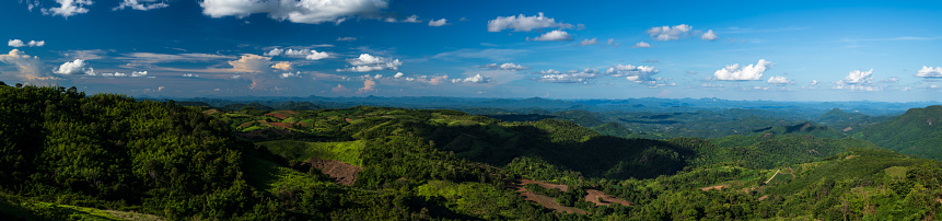 Wide panoramic view of mountains with blue sky.