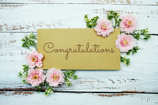 Congratulations typography text decorate with flower on wooden background