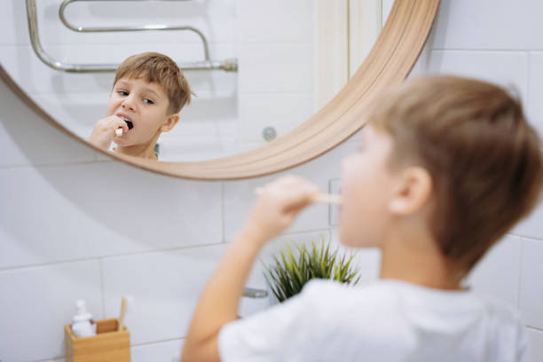 istock cute 5 years old boy brushing teeth with bamboo tooth brush in bathroom. Image with selective focus 1662751097