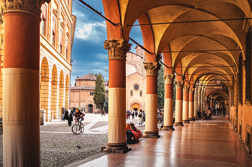 Bologna, Italy - March 10, 2023: People in historical pedestrian zone with beautifully decorated Portici - porch with colonnade in Bologna, Italy