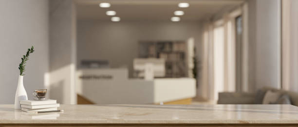 istock Empty mockup space on a tabletop with a blurred, modern reception room in the background. 1662775329